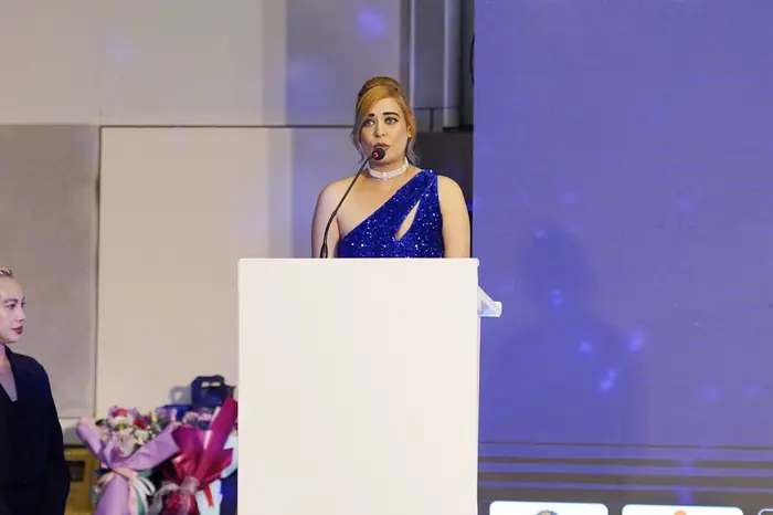 Pooja Sudha delivering a speech at the Club of Achievers podium