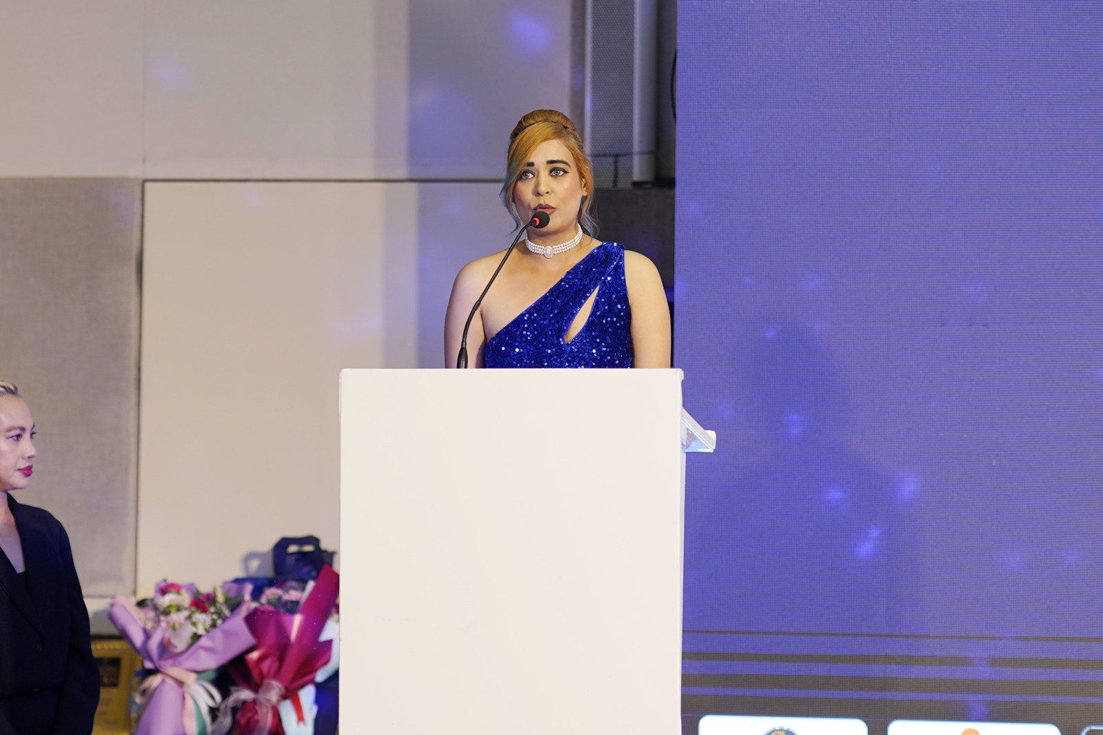Pooja Sudha delivering a speech at the Club of Achievers podium