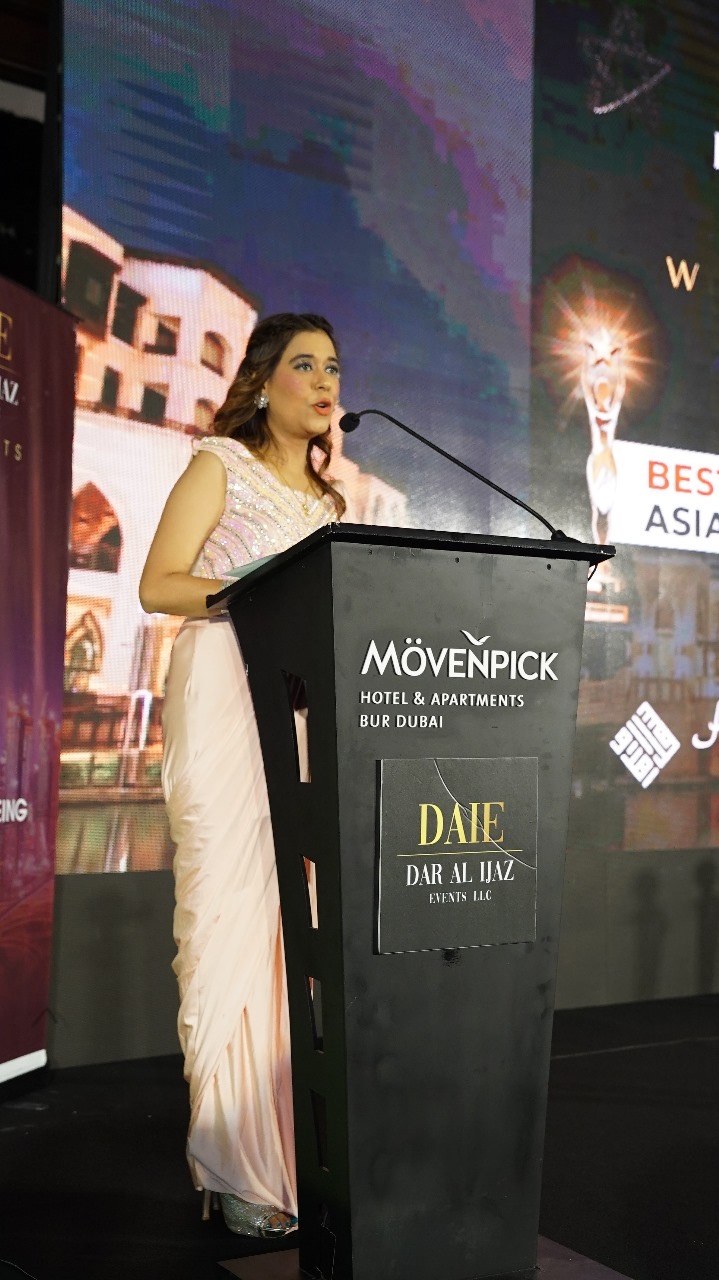 Pooja Sudha speaking at the DAIE awards podium