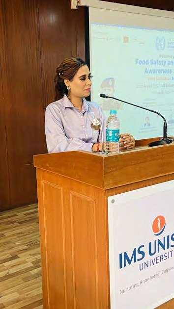 Pooja Sudha as master of ceremonies at a corporate podium